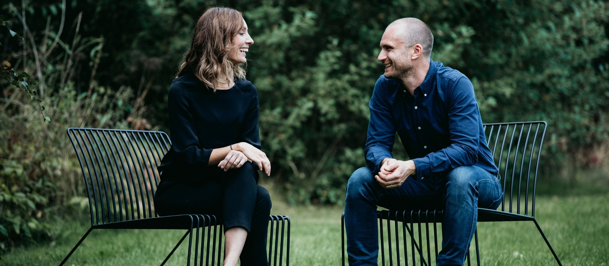 Sofie och Johan sitter på varsin loungestol i naturen