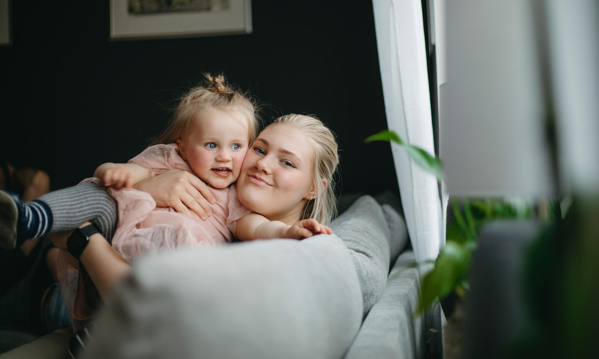 mamma och dotter leker i soffan