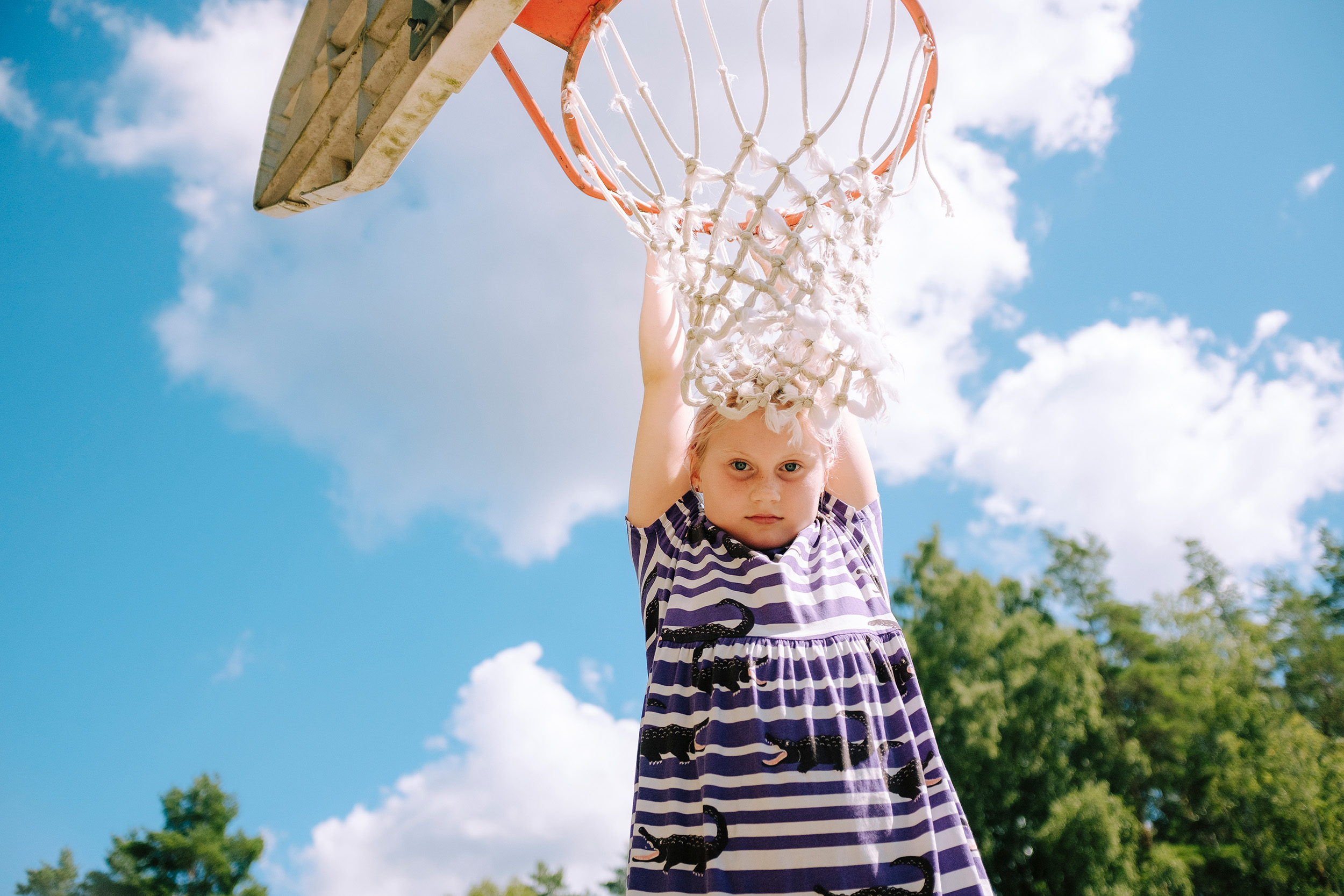 Tjej hänger i basketkorg